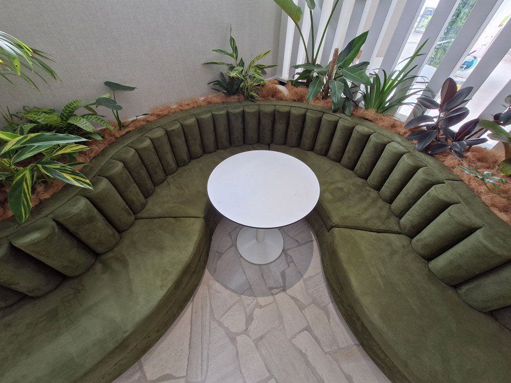 Bolsters made out of green fabric plus custom curved squab seating with round table