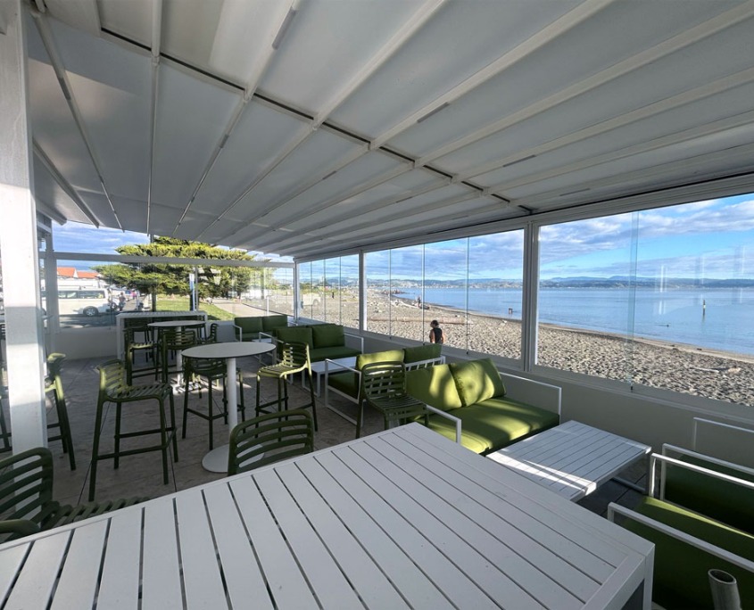 Cocktail bar outdoor area with retractable roof with ocean and blue sky in the background