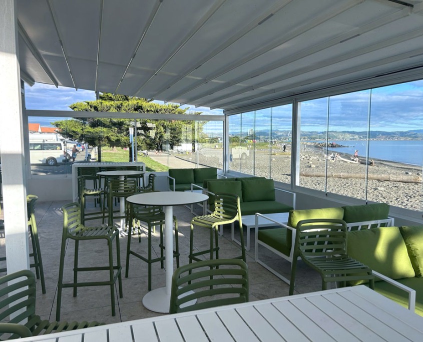 Cocktail bar outdoor area with retractable roof with tree and blue sky in the background